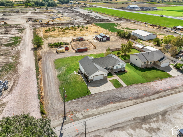 1045 West 3600th South Perry, UT 84302 - Photo 55 of 57 White exterior with an attached garage, paved driveway, and a front walk leading to the entry