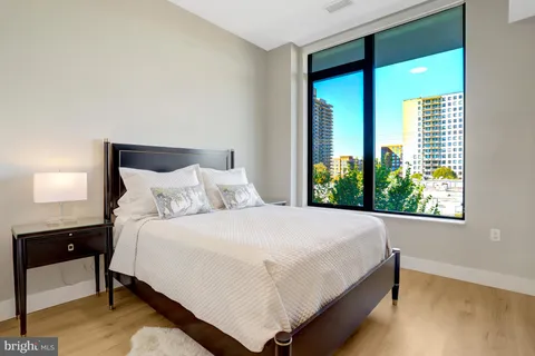 a large bed sitting in a bedroom next to a window