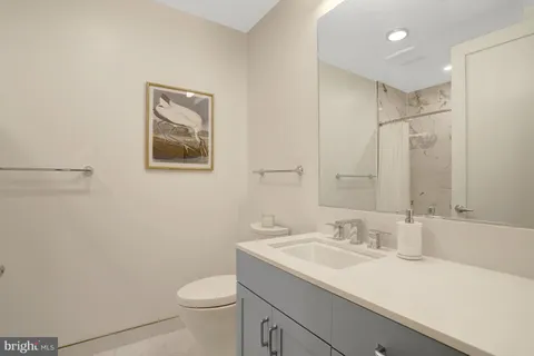 a bathroom with a sink toilet and a mirror