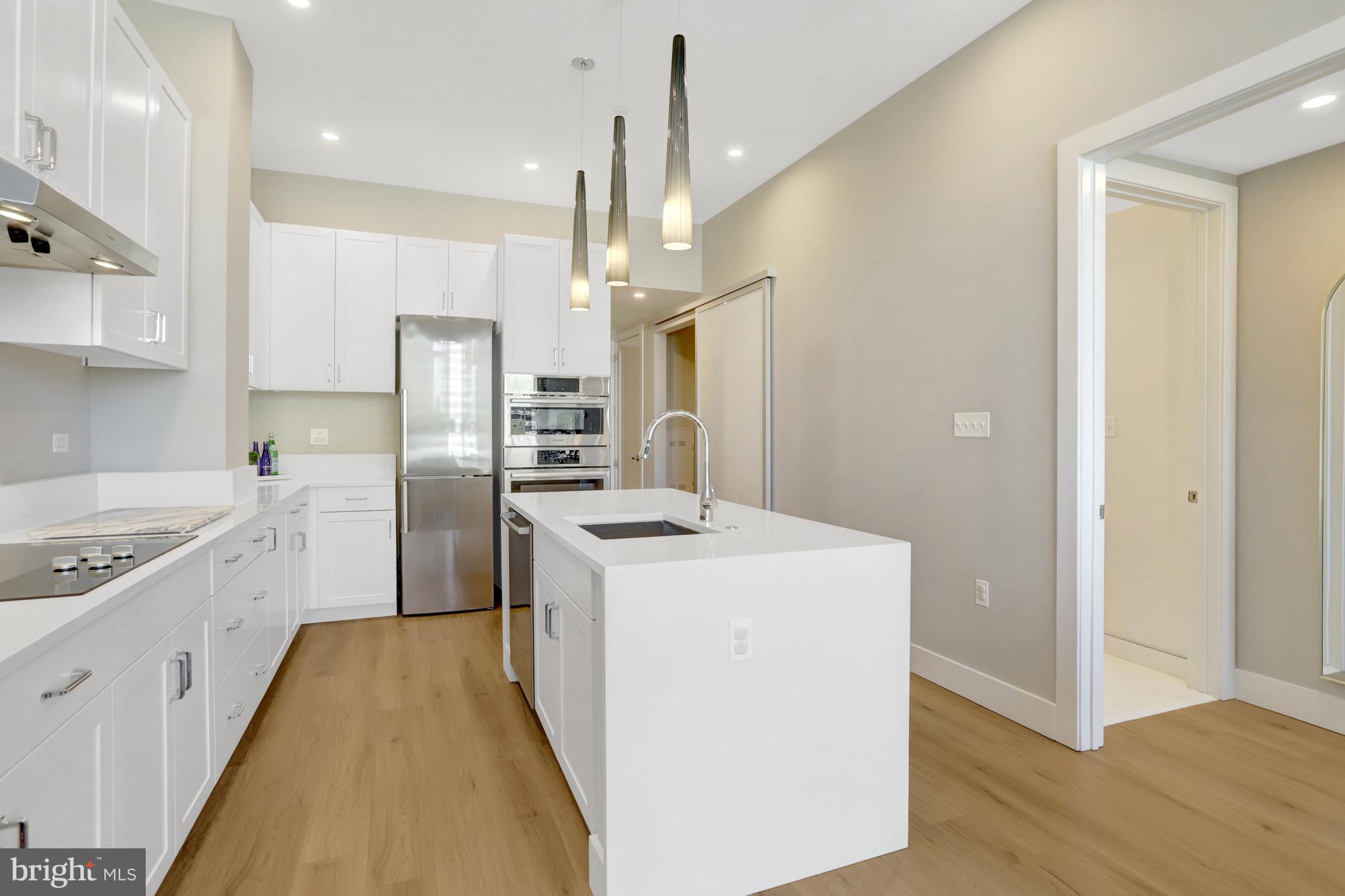 801 North Fairfax Street, Unit 314 Alexandria, VA 22314 - Photo 5 of 61 a kitchen with a sink a counter top space stainless steel appliances and cabinets