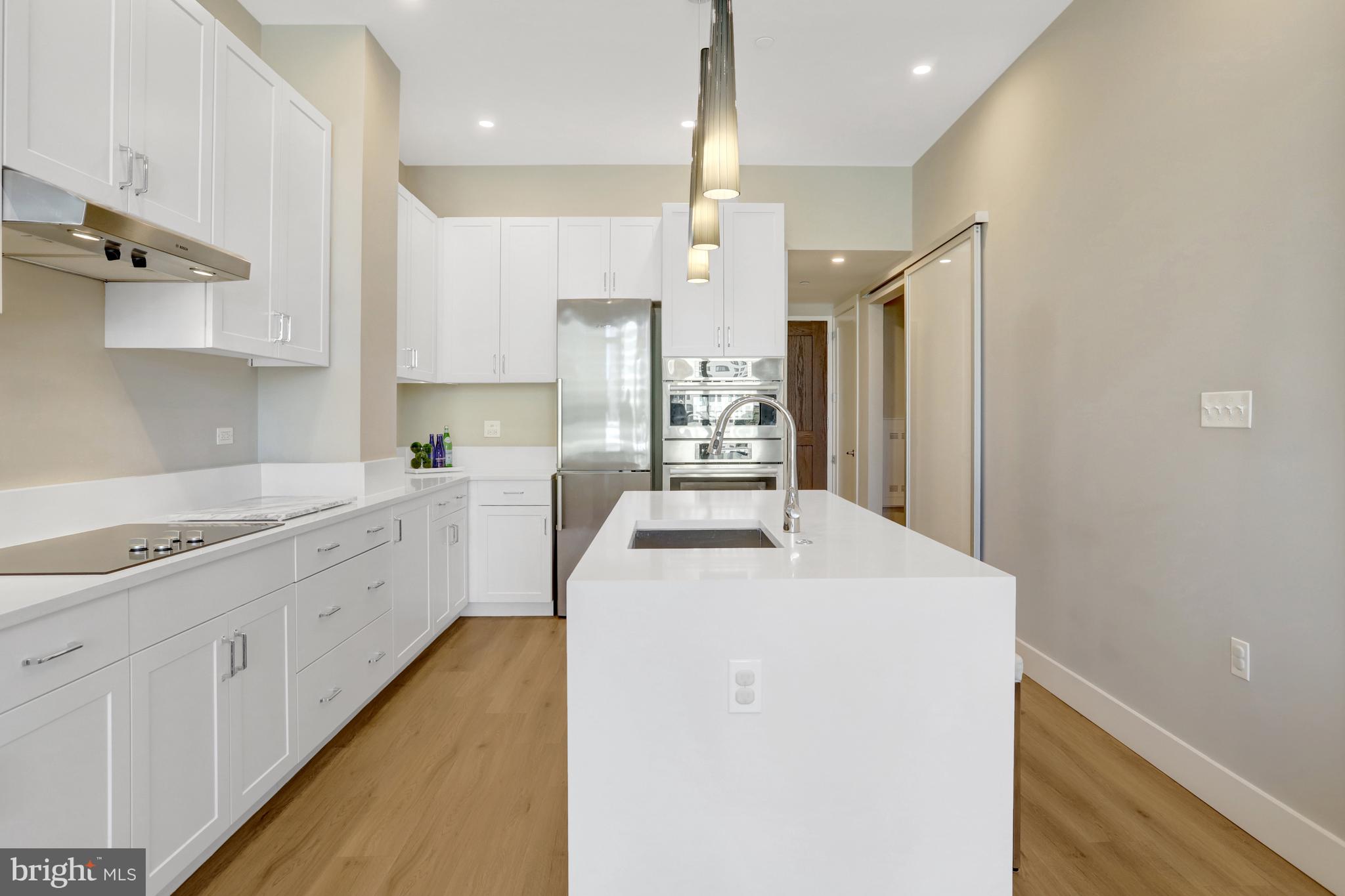 801 North Fairfax Street, Unit 314 Alexandria, VA 22314 - Photo 6 of 61 a kitchen with a sink a stove a refrigerator and white cabinets