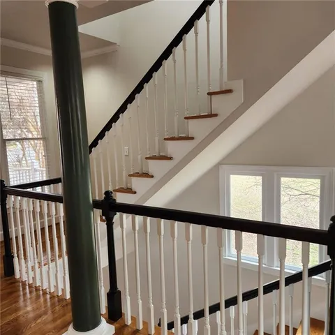 a view of a hallway with wooden floor and staircase