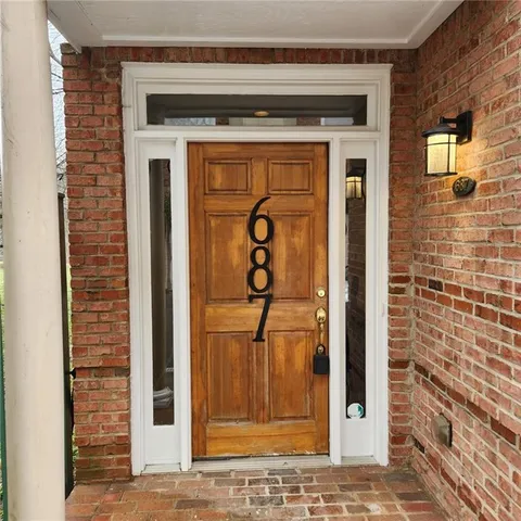 a view of a hallway with wooden floor and entryway