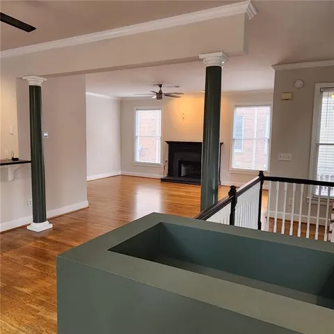 a view of a livingroom with wooden floor and a fireplace