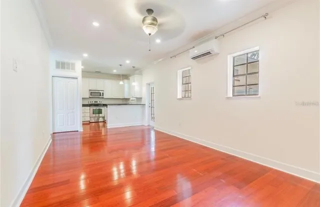 a view of kitchen with kitchen island wooden floor center island and stainless steel appliances