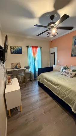 a bedroom with a bed chandelier painting on the wall and a flat screen tv