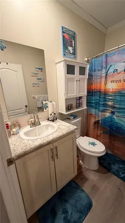 a bathroom with a granite countertop sink mirror vanity and toilet
