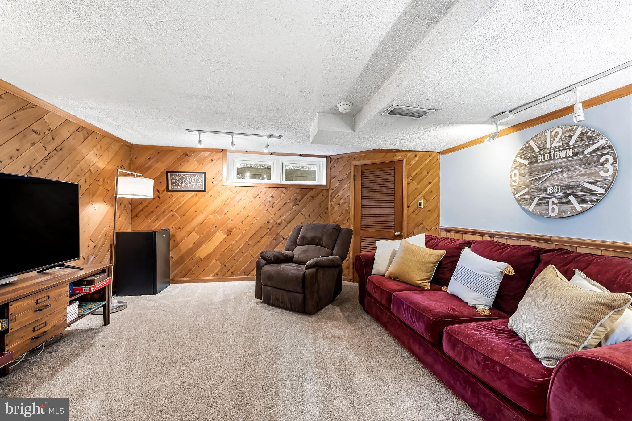 6745 Glenkirk Road Baltimore, MD 21239 - Photo 26 of 35 a living room with furniture and a flat screen tv