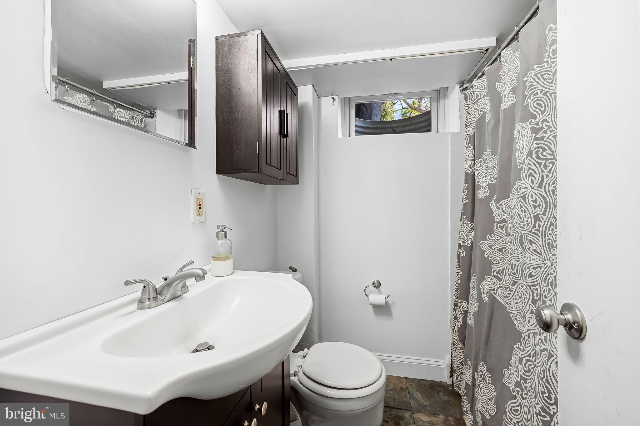 6745 Glenkirk Road Baltimore, MD 21239 - Photo 27 of 35 a bathroom with a sink toilet and shower