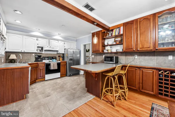 a kitchen with stainless steel appliances granite countertop wooden cabinets a dining table and chairs