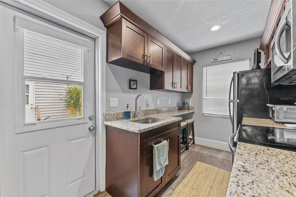 1326 17th Terrace North St. Petersburg, FL 33704 - Photo 7 of 28 a kitchen with stainless steel appliances granite countertop a sink stove and refrigerator