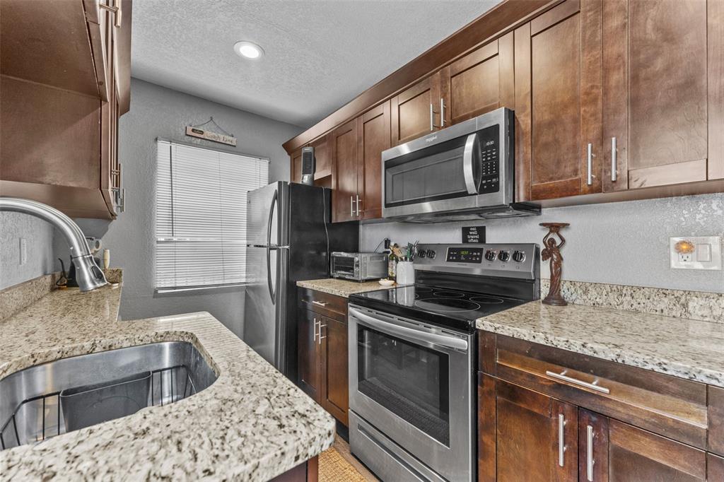 1326 17th Terrace North St. Petersburg, FL 33704 - Photo 8 of 28 a kitchen with stainless steel appliances granite countertop a sink stove and refrigerator