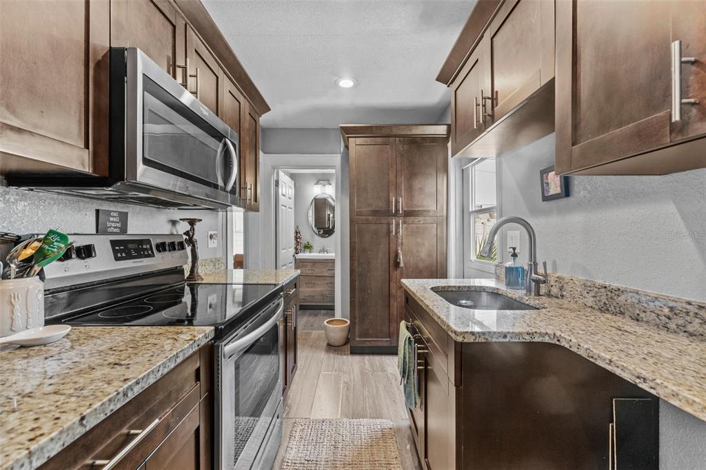 1326 17th Terrace North St. Petersburg, FL 33704 - Photo 9 of 28 a kitchen with stainless steel appliances granite countertop a sink a stove and a refrigerator