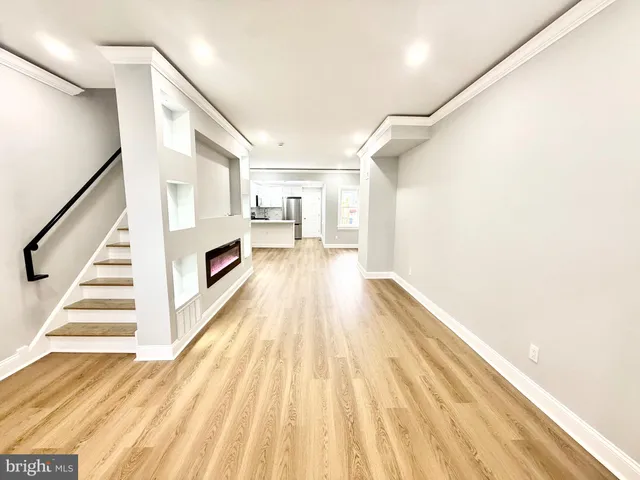 a view of a hallway with wooden floor and staircase