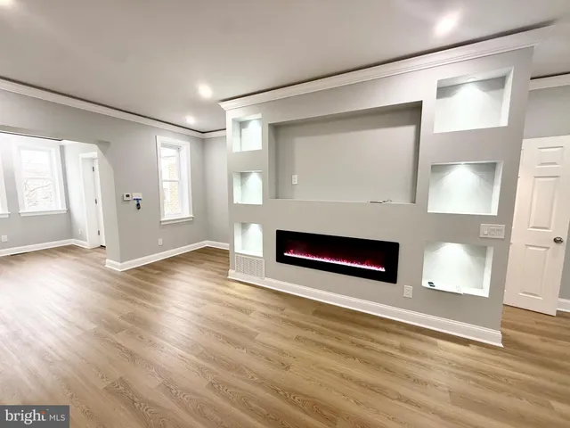 a view of a livingroom with wooden floor and a kitchen