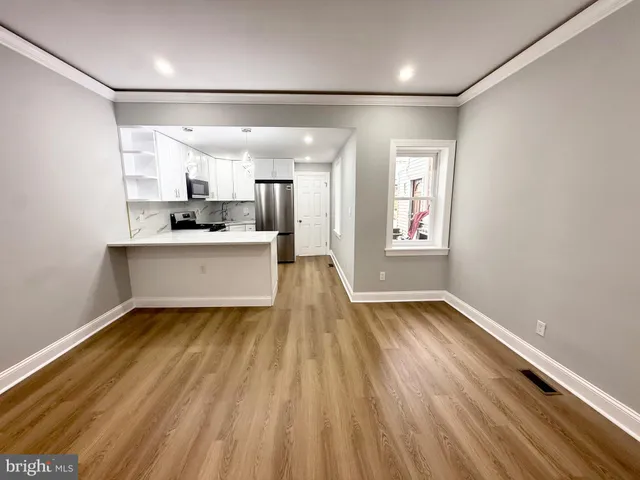 a view of a big room with wooden floor and windows