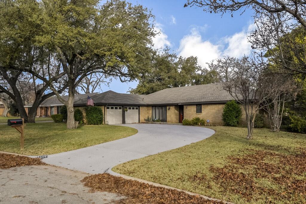a front view of a house with a yard and trees