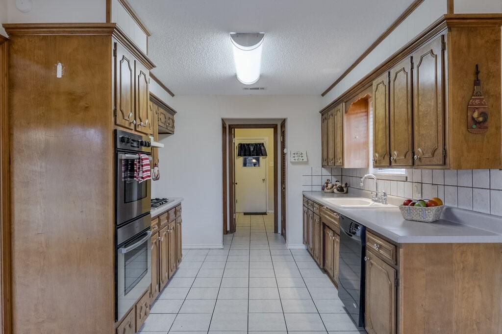 1609 Delta Drive Arlington, TX 76012 - Photo 11 of 28 a kitchen with stainless steel appliances granite countertop a refrigerator and a sink