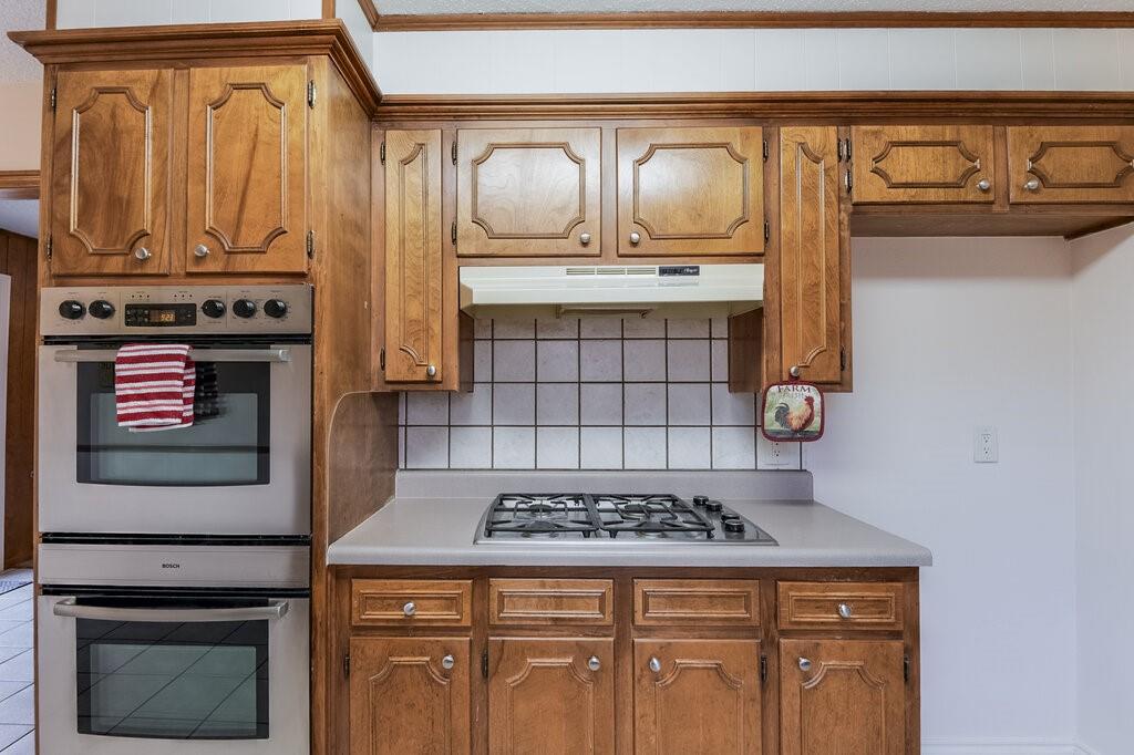 1609 Delta Drive Arlington, TX 76012 - Photo 13 of 28 a kitchen with granite countertop a stove top oven cabinets and a refrigerator