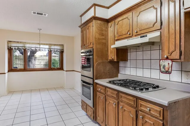 a kitchen with stainless steel appliances a stove a sink and a refrigerator