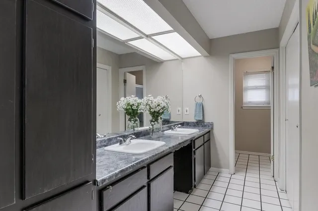 a bathroom with a granite countertop sink a mirror and a shower