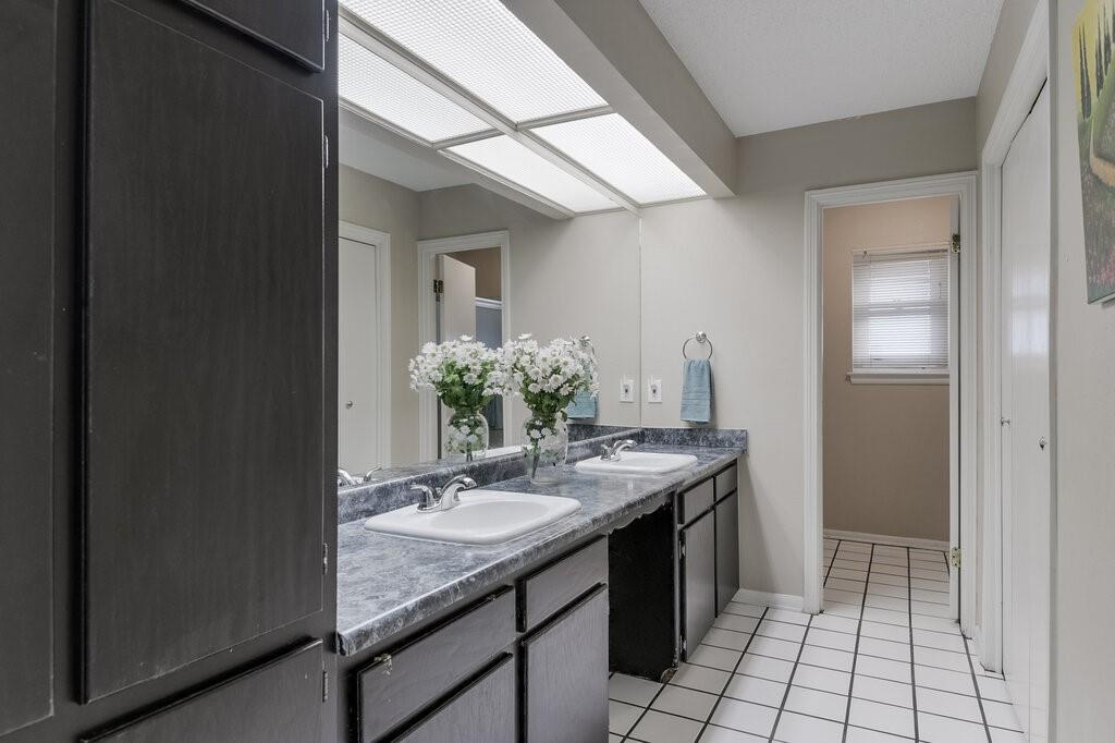 1609 Delta Drive Arlington, TX 76012 - Photo 18 of 28 a bathroom with a granite countertop sink a mirror and a shower