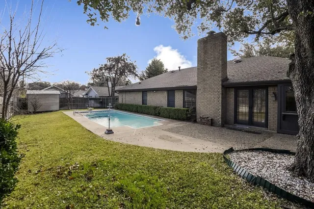 a view of a backyard with swimming pool