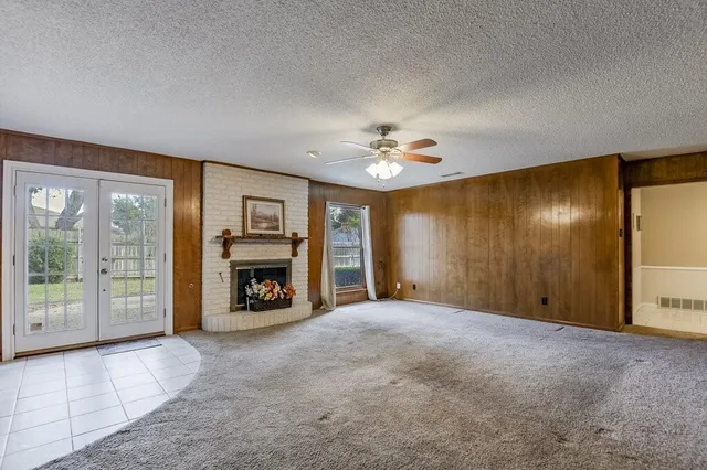 a view of an empty room with a fireplace and a large window