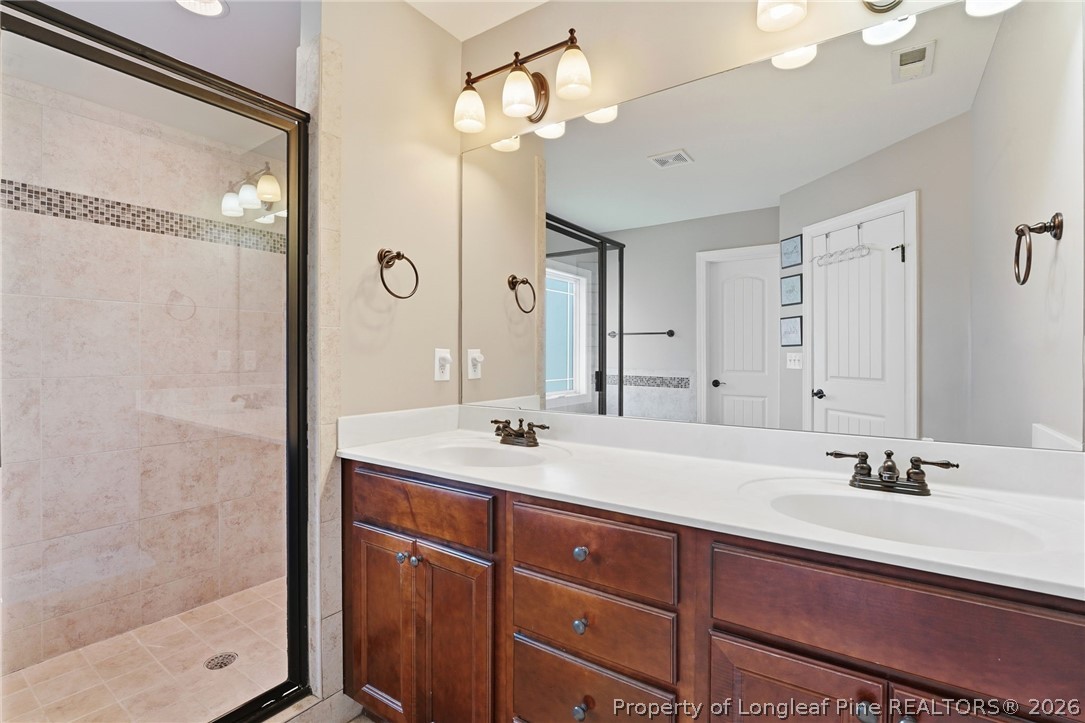 886 Micahs Way North Spring Lake, NC 28390 - Photo 22 of 50 a bathroom with a double vanity sink mirror and shower