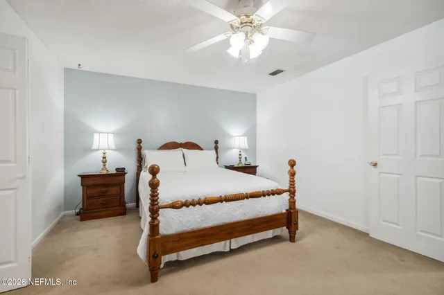 a bedroom with a large bed and a chandelier
