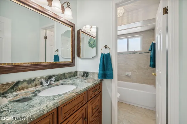 a view of a room with a hanging light and hardwood