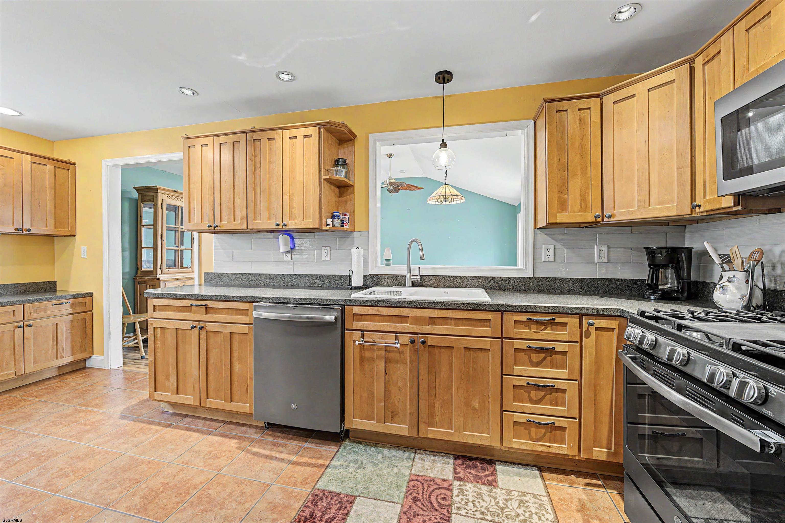 125 Exton Road Somers Point, NJ 08244 - Photo 13 of 35 a kitchen with stainless steel appliances granite countertop a stove a sink and a microwave
