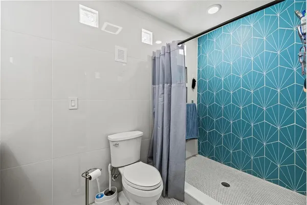 a bathroom with a toilet and shower