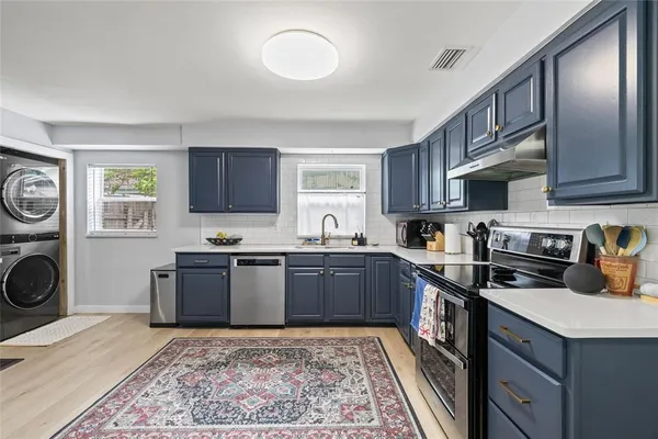 a kitchen with stainless steel appliances granite countertop a stove sink microwave and cabinets