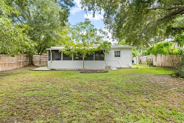 a backyard of a house with large trees and entertaining space