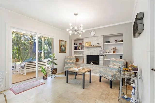 a living room with furniture a fireplace and a large window