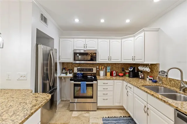 a kitchen with stainless steel appliances granite countertop a refrigerator and a sink