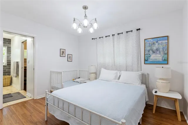 a bedroom with a large bed and a chandelier