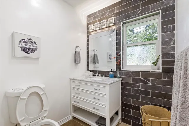 a bathroom with a toilet a sink and a mirror