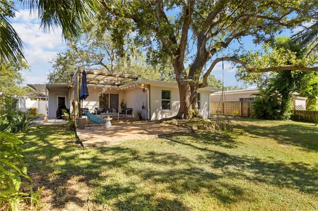 a view of a house with backyard and tree