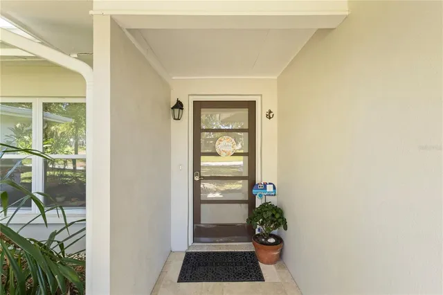 a view of a hallway with wooden floor and a potted plant