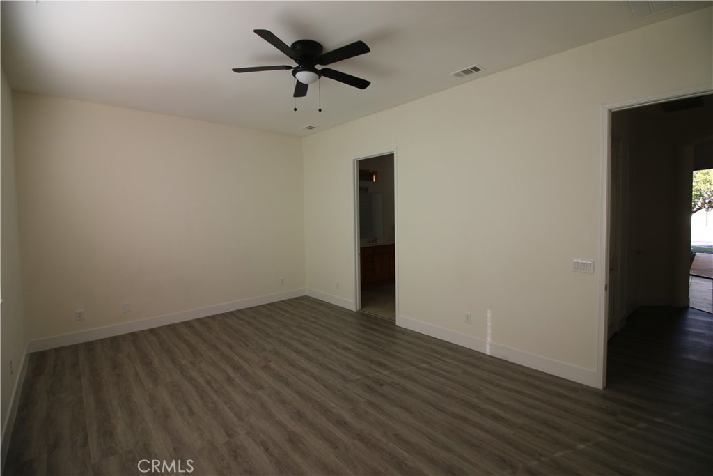 805 Annandale Road Beaumont, CA 92223 - Photo 12 of 39 an empty room with wooden floor and a hallway