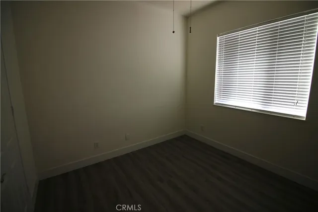 a view of a small space with wooden floor and a window