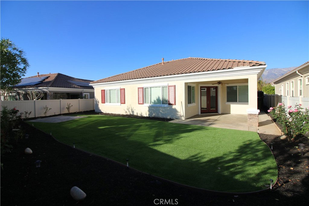 805 Annandale Road Beaumont, CA 92223 - Photo 36 of 39 a view of a white house with a big yard potted plants and large tree