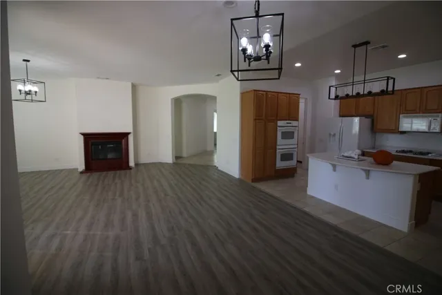 a open kitchen with a refrigerator and a stove top oven