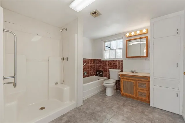 a bathroom with a granite countertop sink a toilet and shower