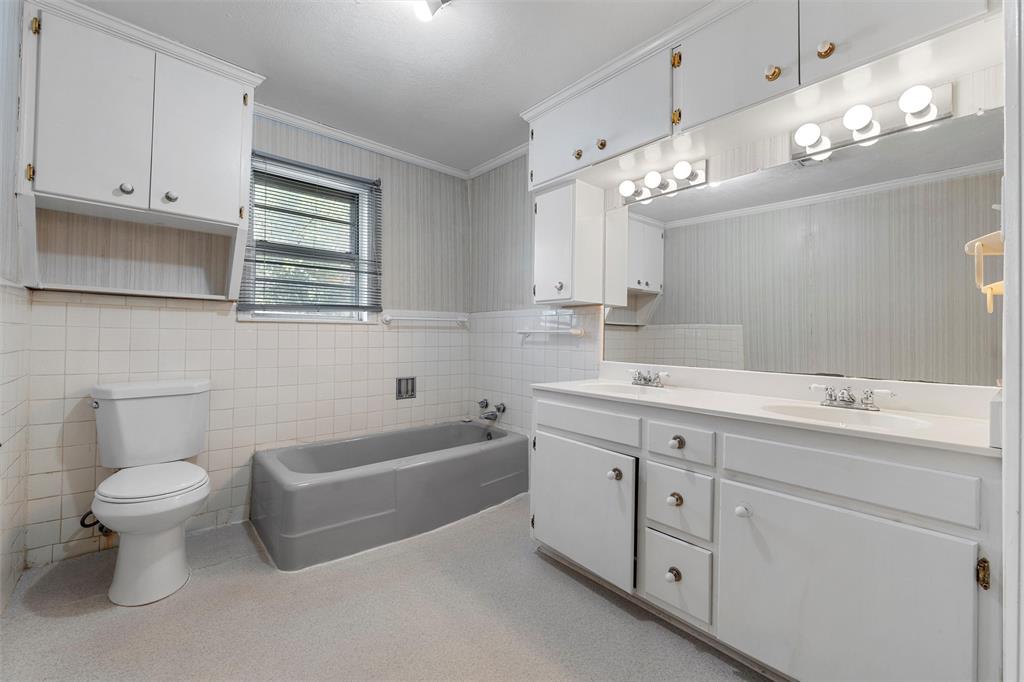12145 Tree Lake Drive Waco, TX 76708 - Photo 26 of 40 a bathroom with a double vanity sink a toilet a mirror and bathtub