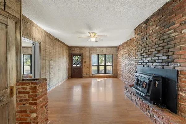 a view of an empty room with exposed radiator and fireplace