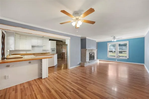 a view of an empty room with window and wooden floor