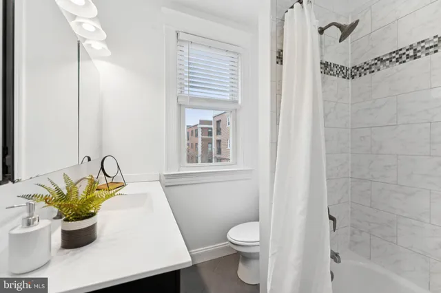 a bedroom with a bed and a chandelier fan